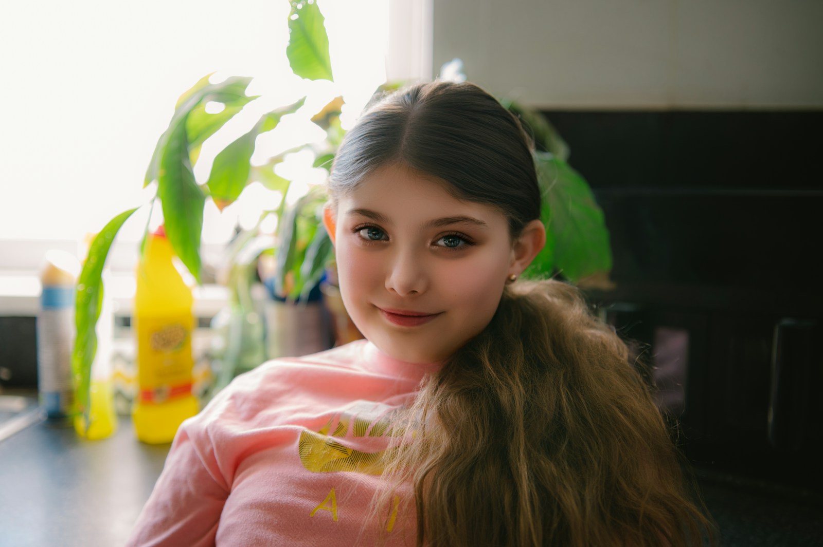 A young girl smiles with long brown hair.