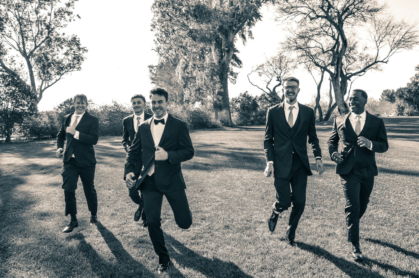 a group of men in suits running across a field