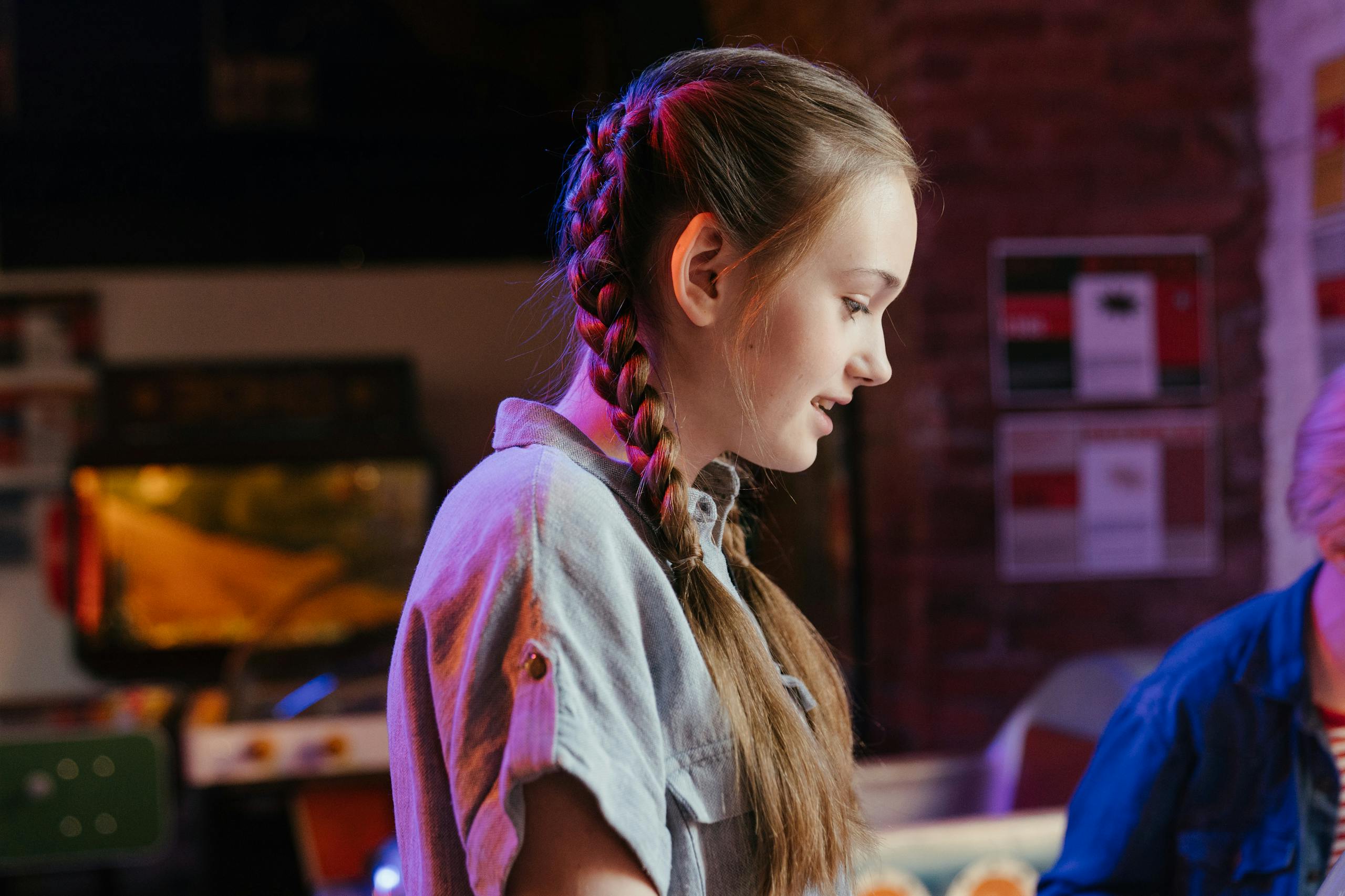 Teenage girl with braided hair indoors, creating a casual and youthful atmosphere.