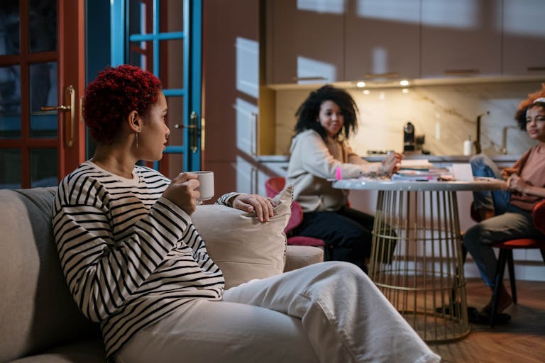 Three women enjoying a relaxed gathering in a stylish and cozy home environment.