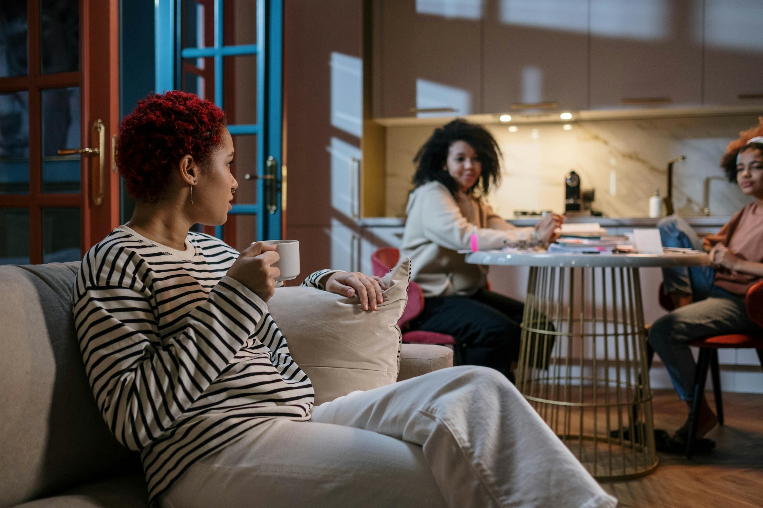 Three women enjoying a relaxed gathering in a stylish and cozy home environment.