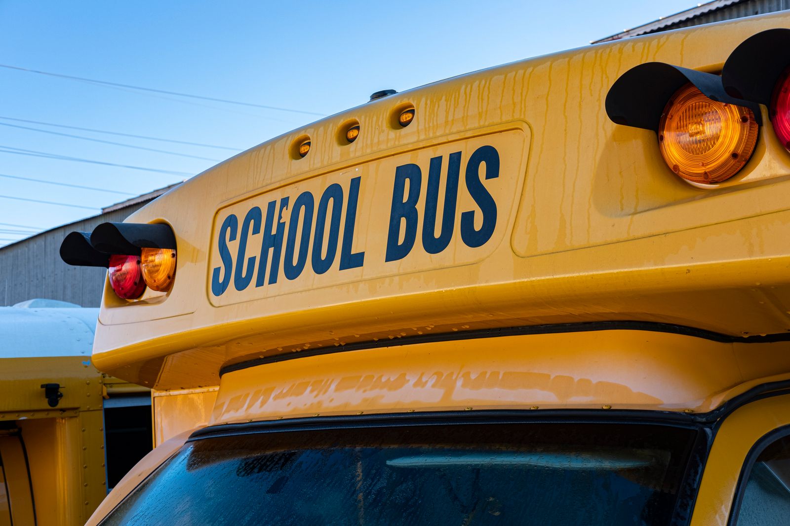 Yellow school bus close-up showing front lights and signage.