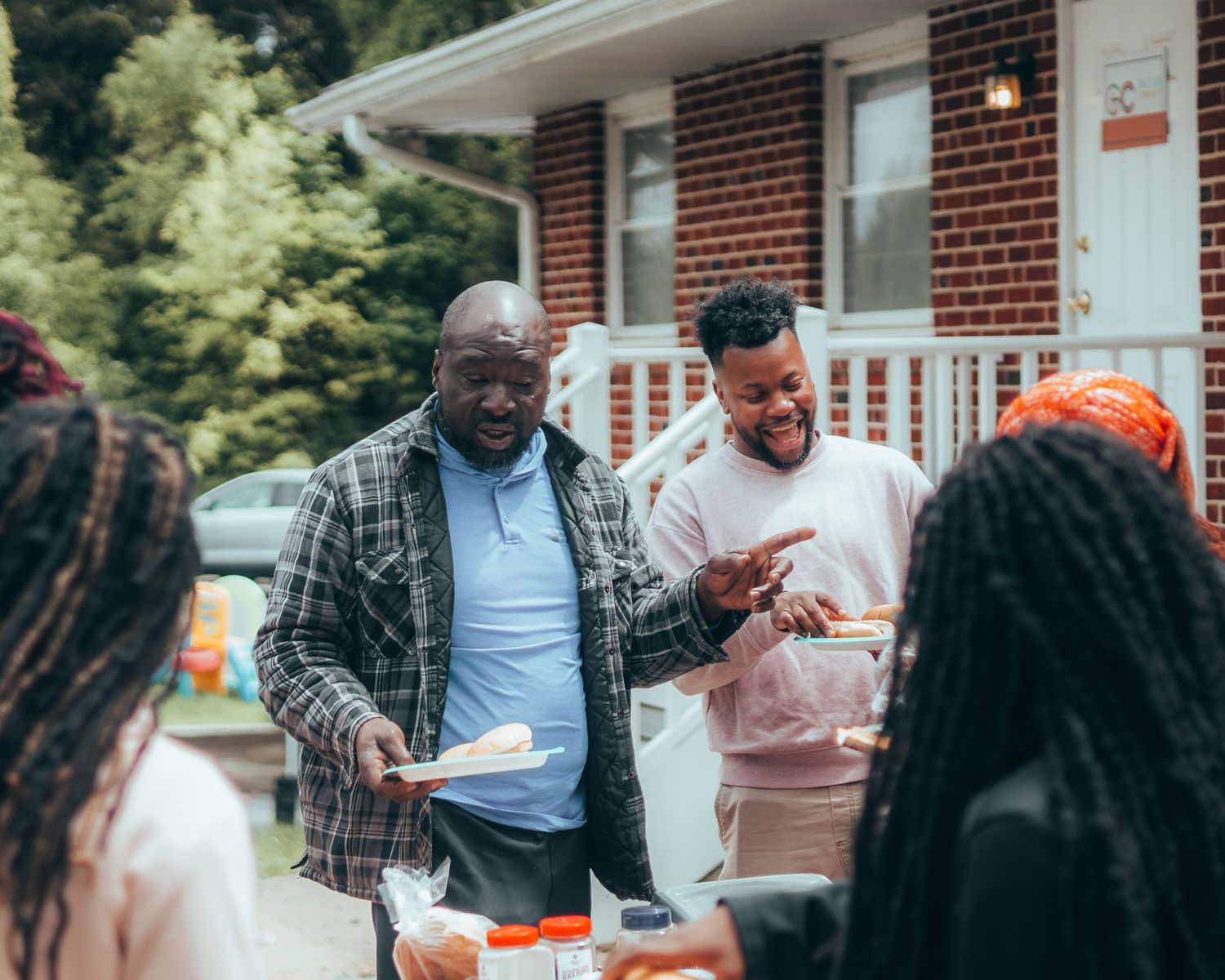 A joyful group of friends enjoying a summer barbecue in a backyard setting.
