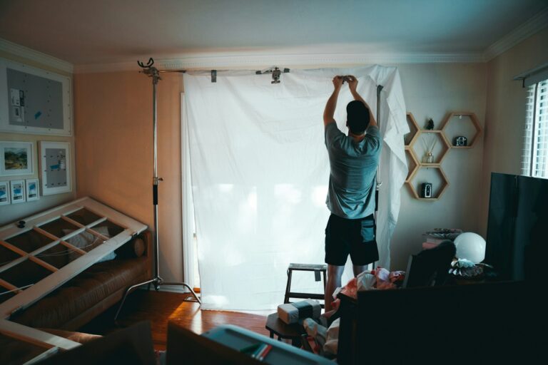 man standing beside white curtain