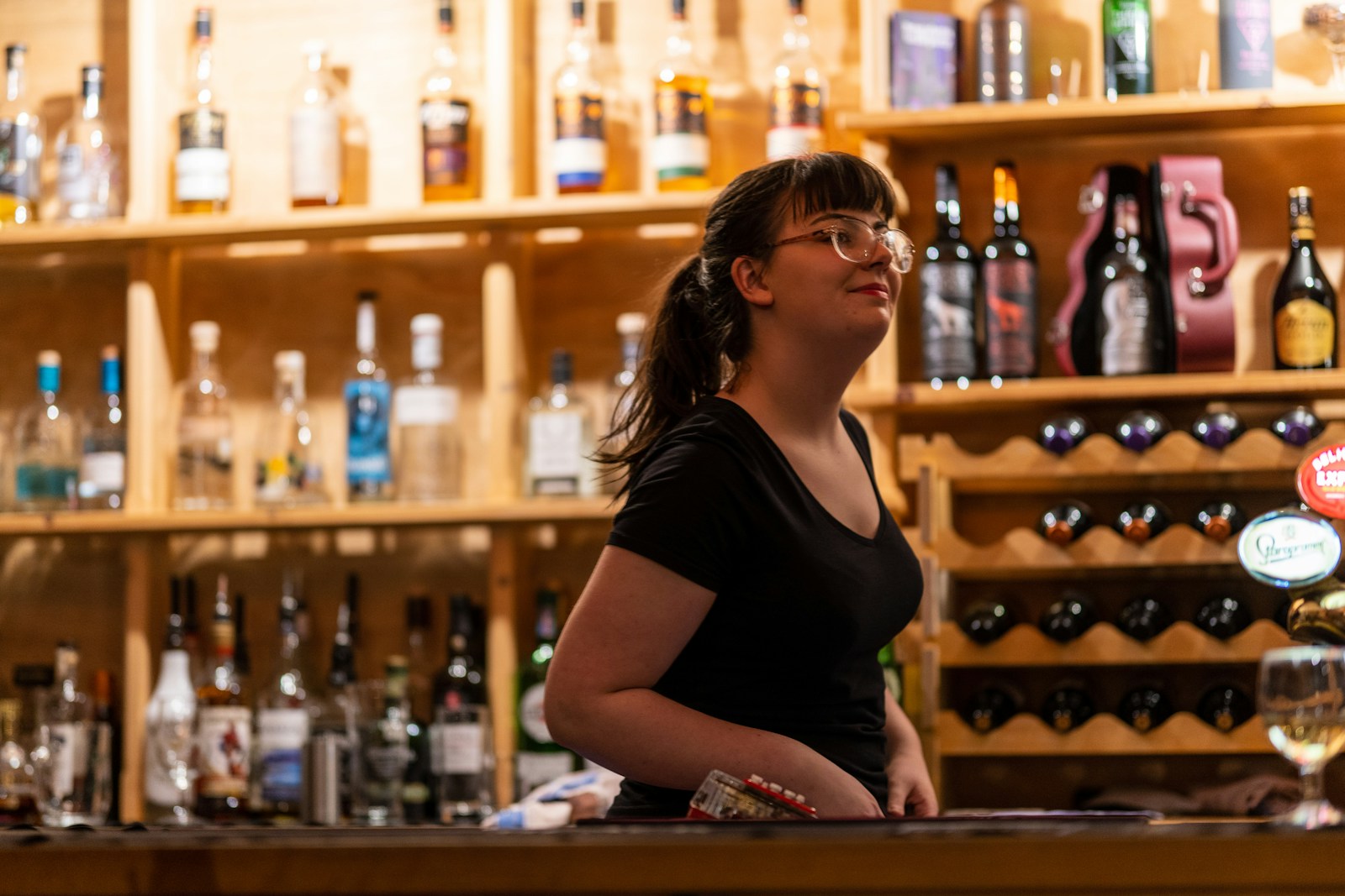 woman in black shirt sitting on bar counter