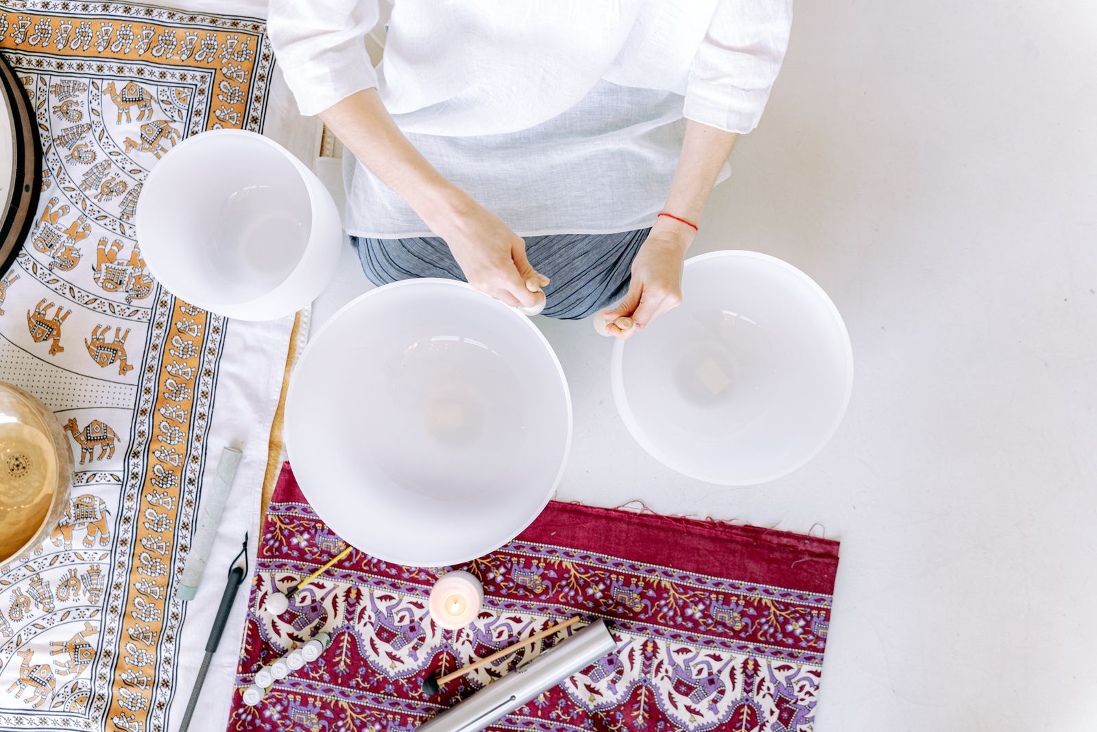 A serene meditation space featuring crystal singing bowls, vibrant mats, and natural lighting.