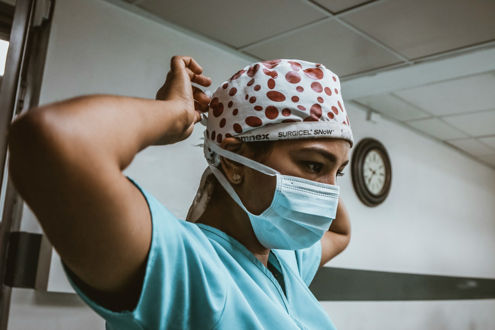 woman in teal shirt wearing white mask