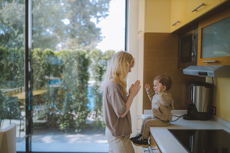 A joyful moment of a mother and child playing together in a bright kitchen.