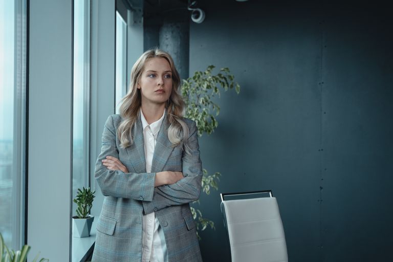 A professional businesswoman stands confidently in a modern office, exuding leadership and determination.