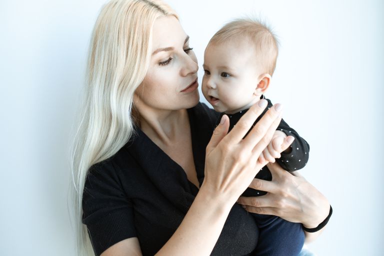 A tender moment of a mother holding her baby, showing love and connection.