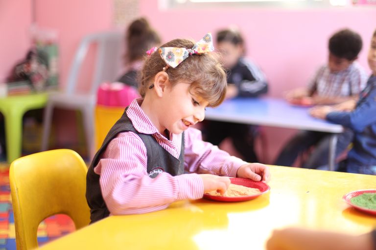 A young girl engages in playful learning in a vibrant Jordanian kindergarten.