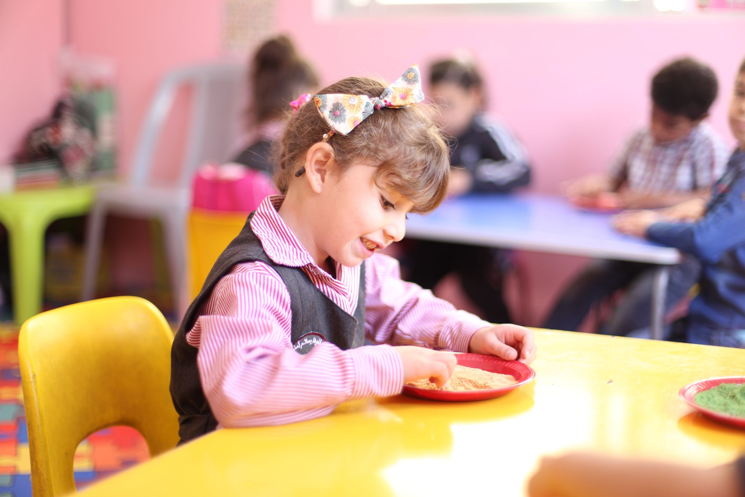 A young girl engages in playful learning in a vibrant Jordanian kindergarten.