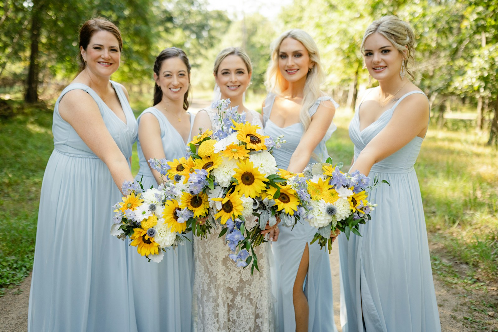 Bride and bridesmaids pose with bouquets.
