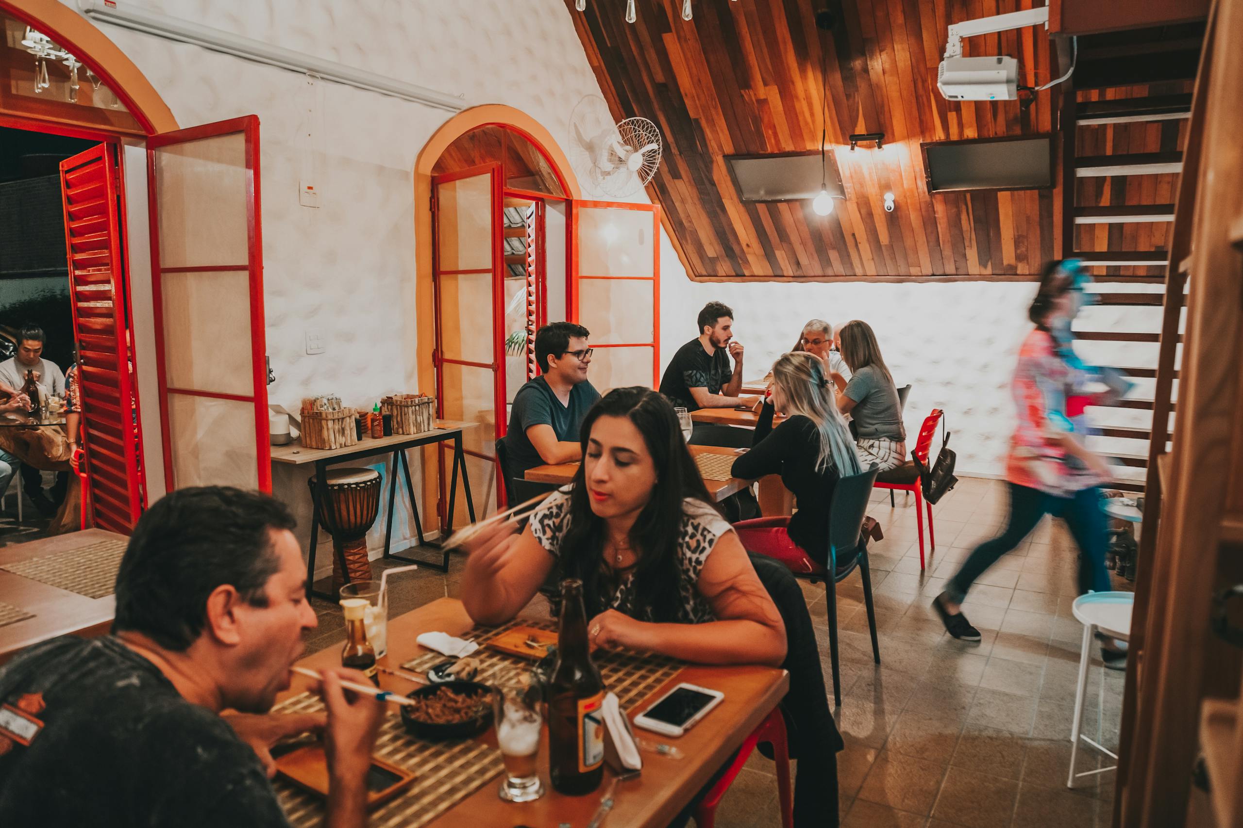 Casual dining scene in a rustic restaurant with people enjoying meals.