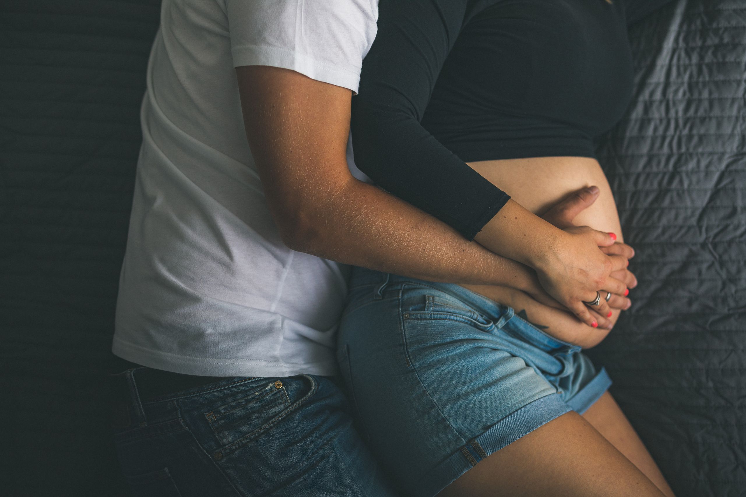 Close-up of a couple lovingly embracing a pregnant belly, symbolizing love and expectation.