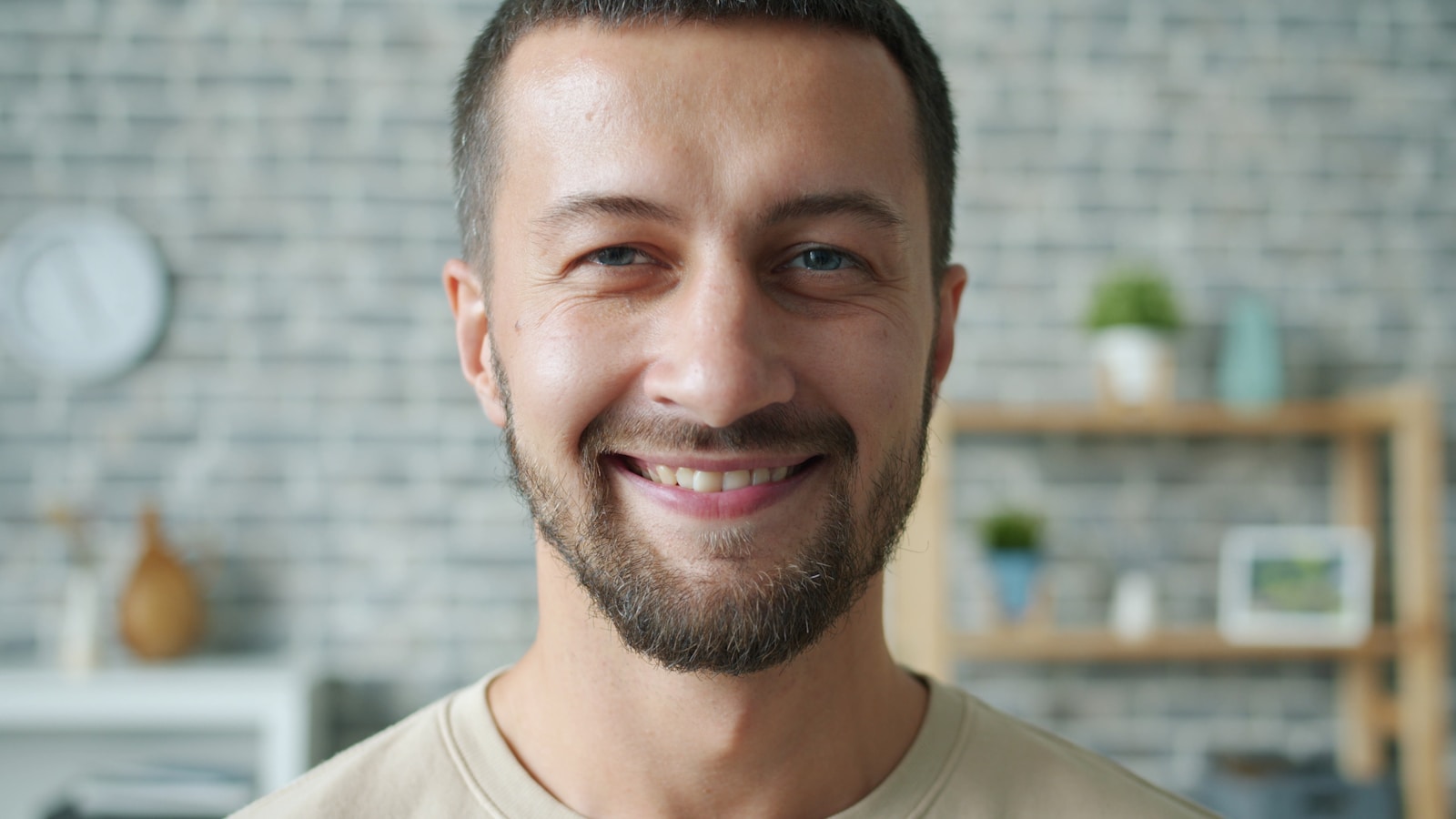 A smiling man with a beard in a casual setting.