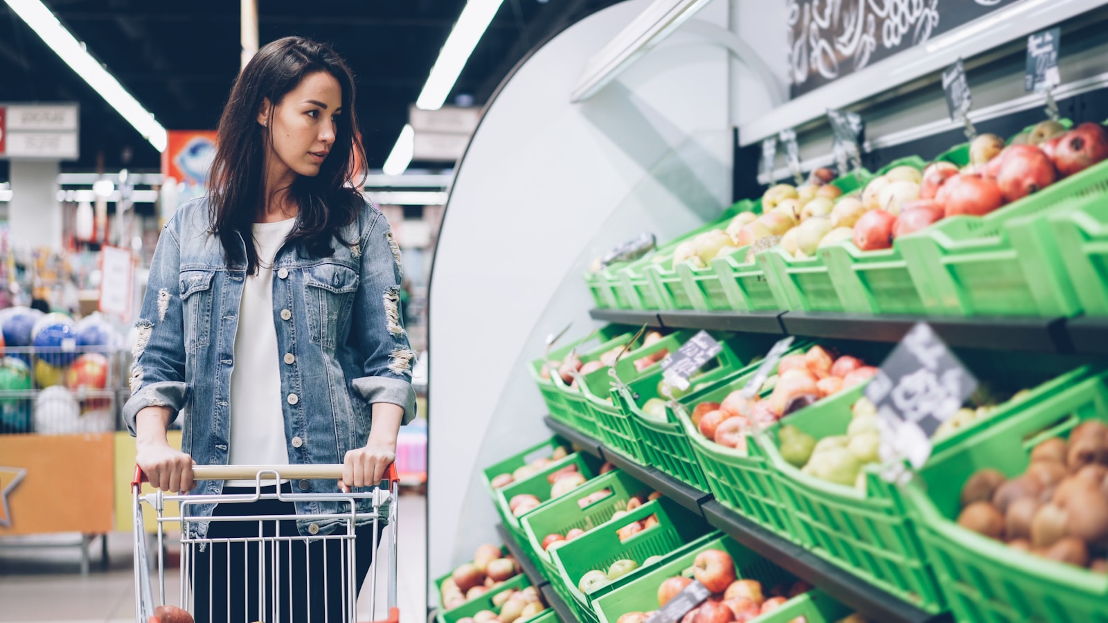 Woman shops for produce at a supermarket.