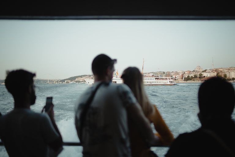 Passengers enjoy the scenic view of Istanbul from a ferry, overlooking the Bosphorus.