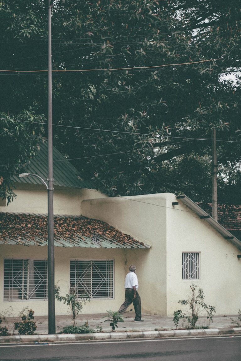 a man walking down the street in front of a house