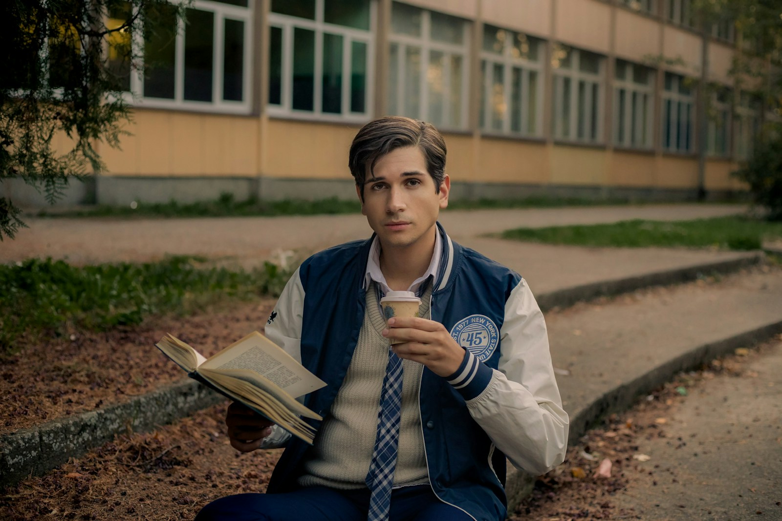 A man sitting on the ground reading a book