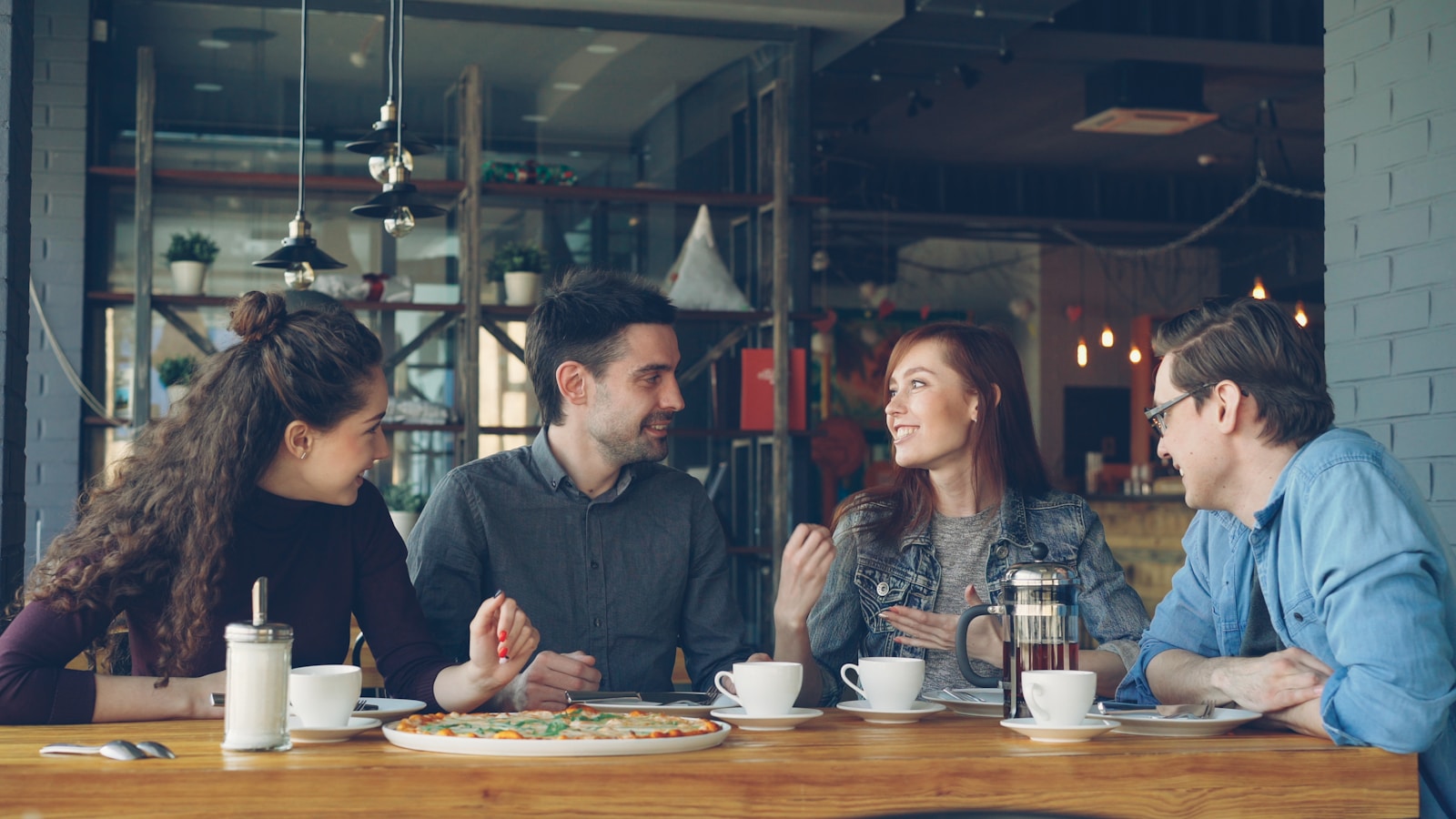 Friends are chatting and having coffee at a cafe.