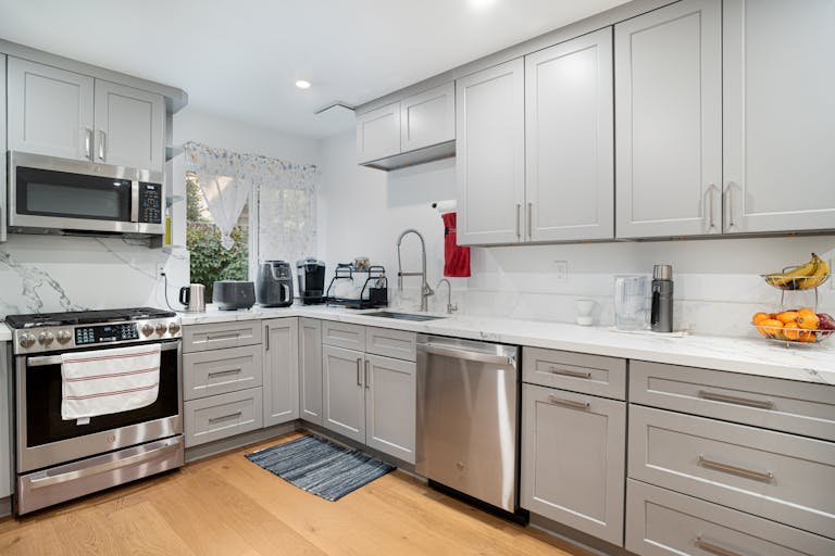 Sleek modern kitchen featuring stainless steel appliances and light grey cabinetry.