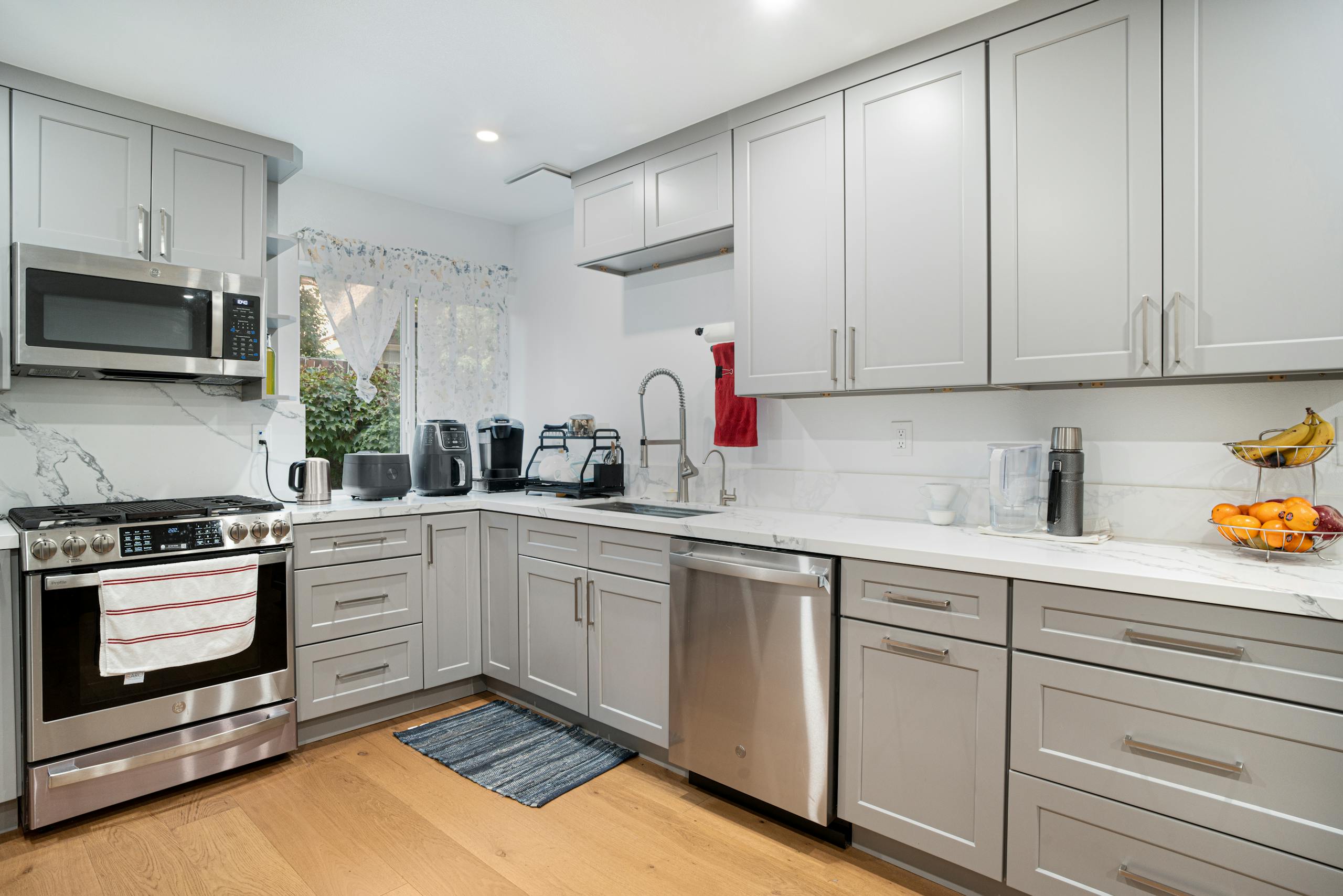 Sleek modern kitchen featuring stainless steel appliances and light grey cabinetry.