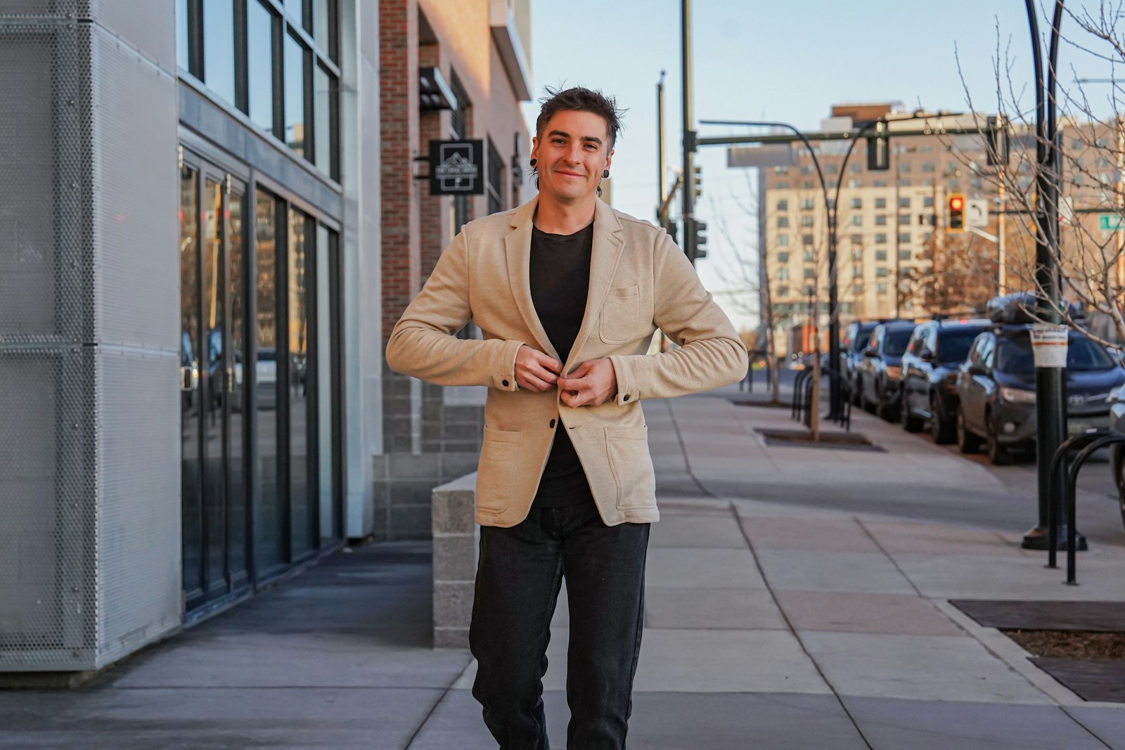 A man standing on a sidewalk in front of a building