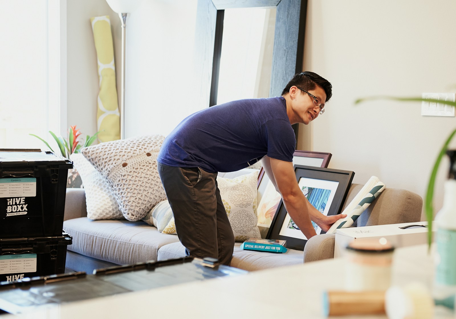 man in blue t-shirt and gray pants sitting on bed