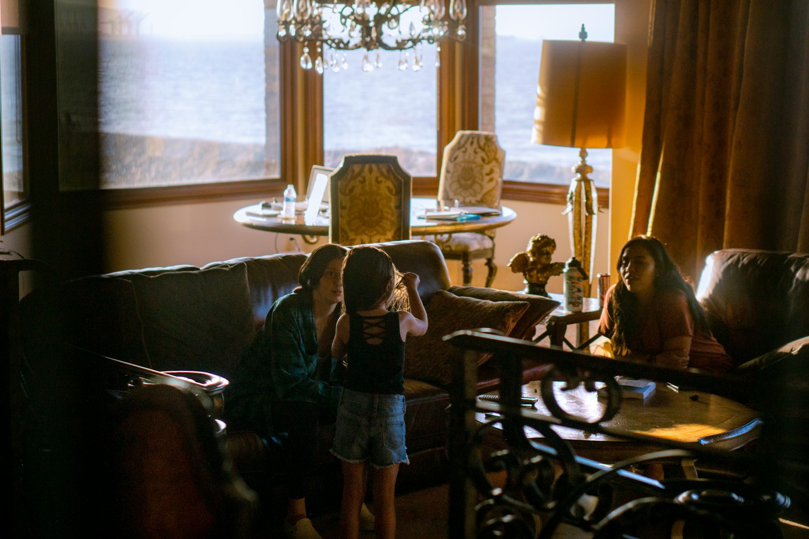 girl in black dress standing beside table