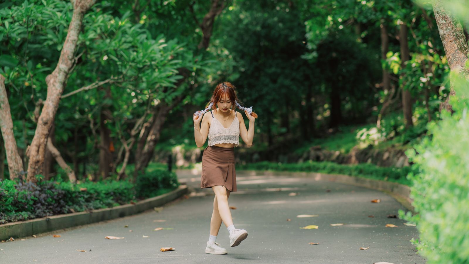 Young woman in white blouse enjoying a summer stroll in Vung Tau park.