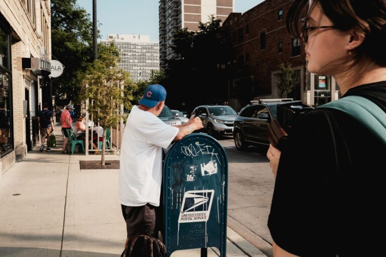 A vibrant street scene in Chicago featuring a USPS mailbox and diverse people.