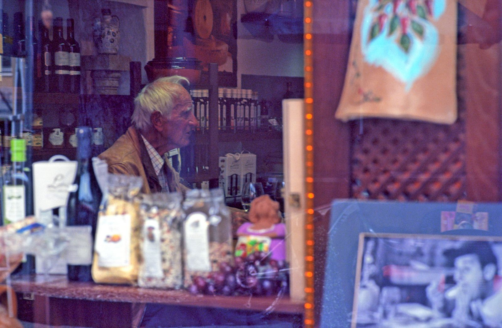 Elderly man seen through a shop window in Matrei in Osttirol, Austria.