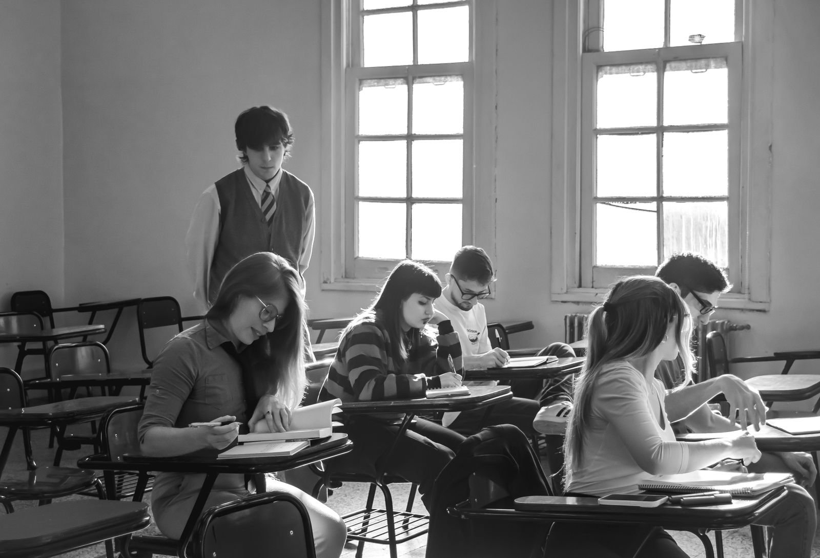 A group of students focusing on their studies in a classroom environment with natural light.