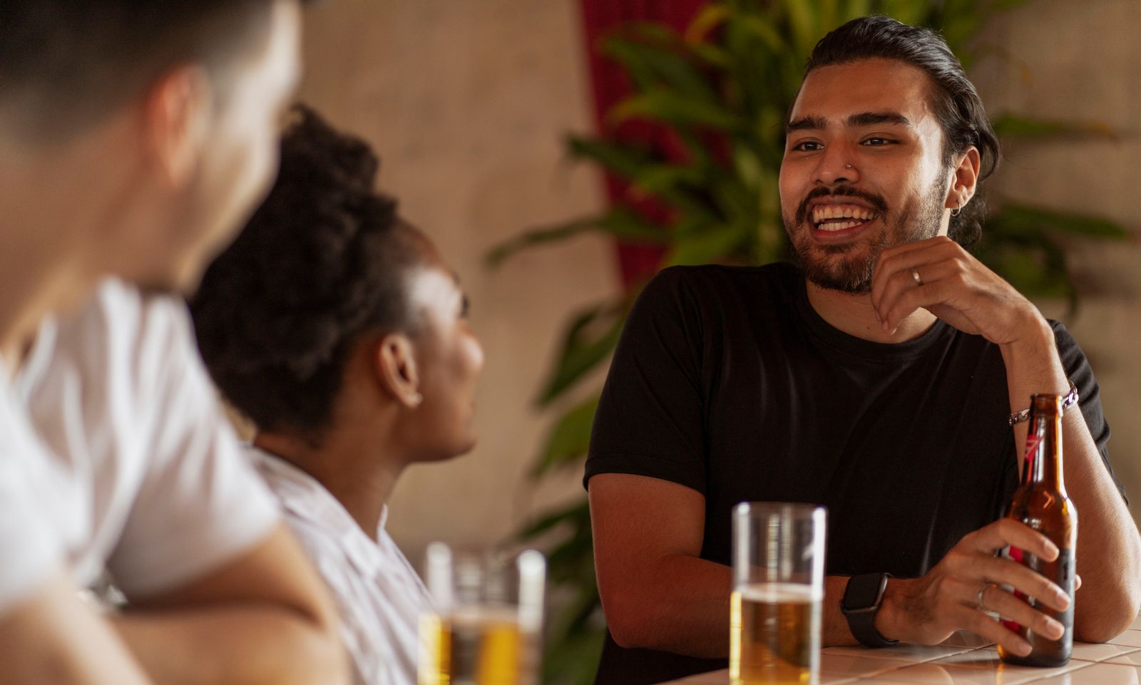 Friends enjoying drinks and conversation at a cozy bar, fostering a relaxed atmosphere.