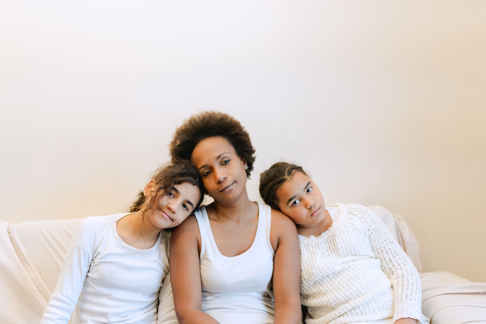A warm family moment showing a mother with her daughters enjoying quality time indoors.
