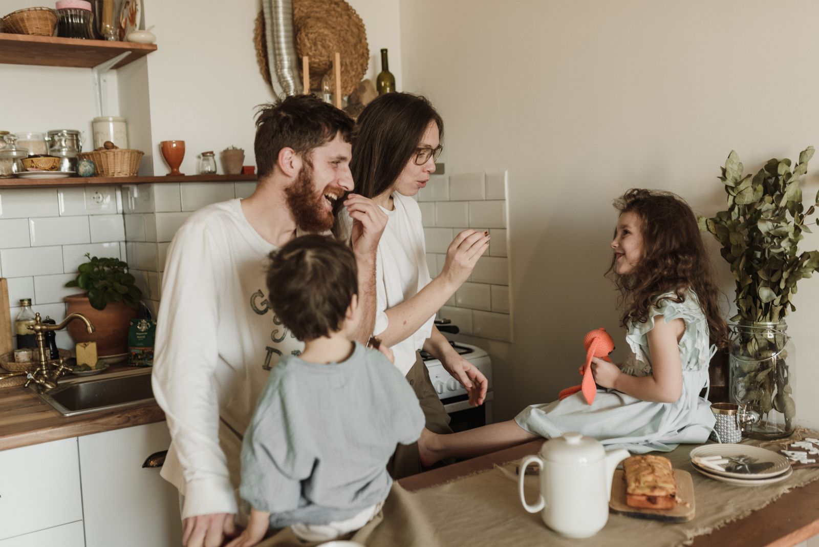 A joyful family shares a moment of laughter in a cozy kitchen, capturing love and togetherness.