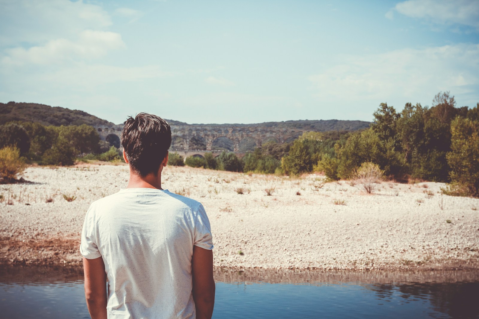 man standing on side of river