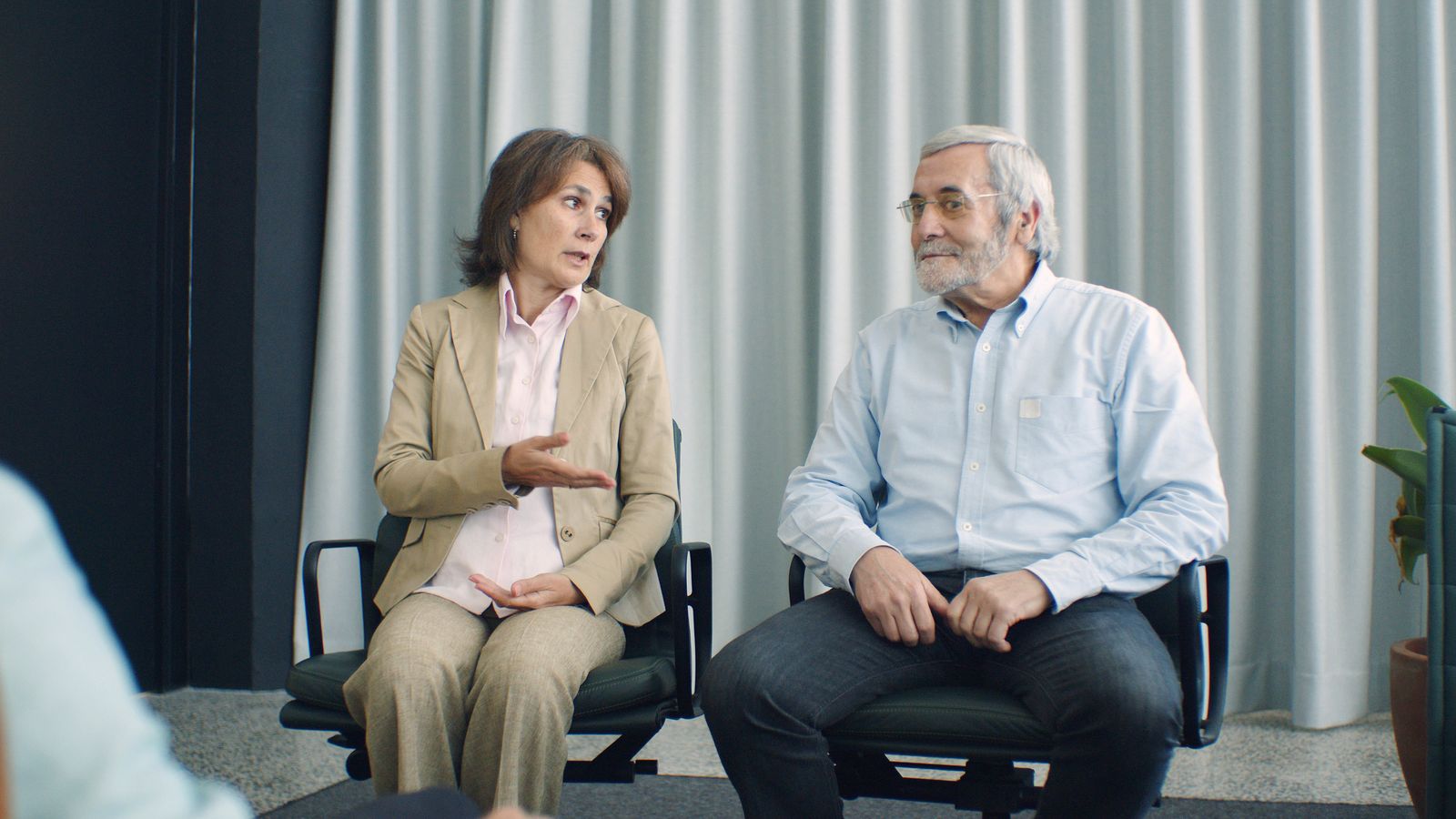 An elderly couple sitting in a counseling session discussing their relationship.