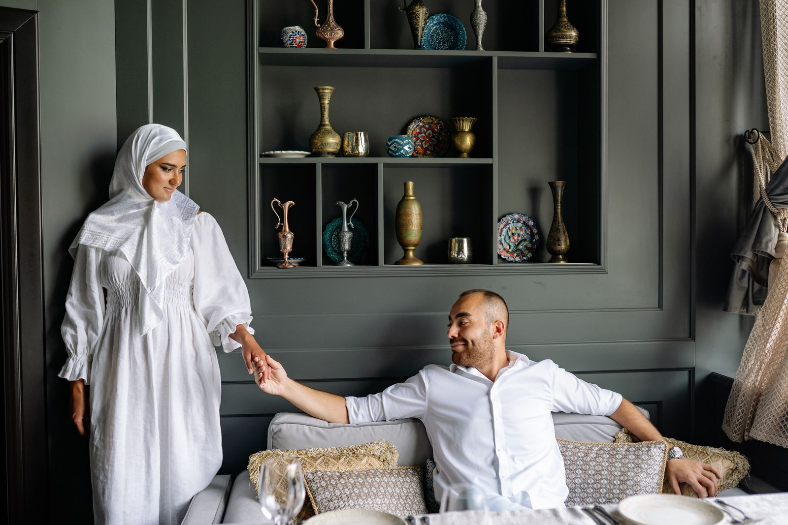 Muslim couple sharing a tender moment in a stylish living room setting.