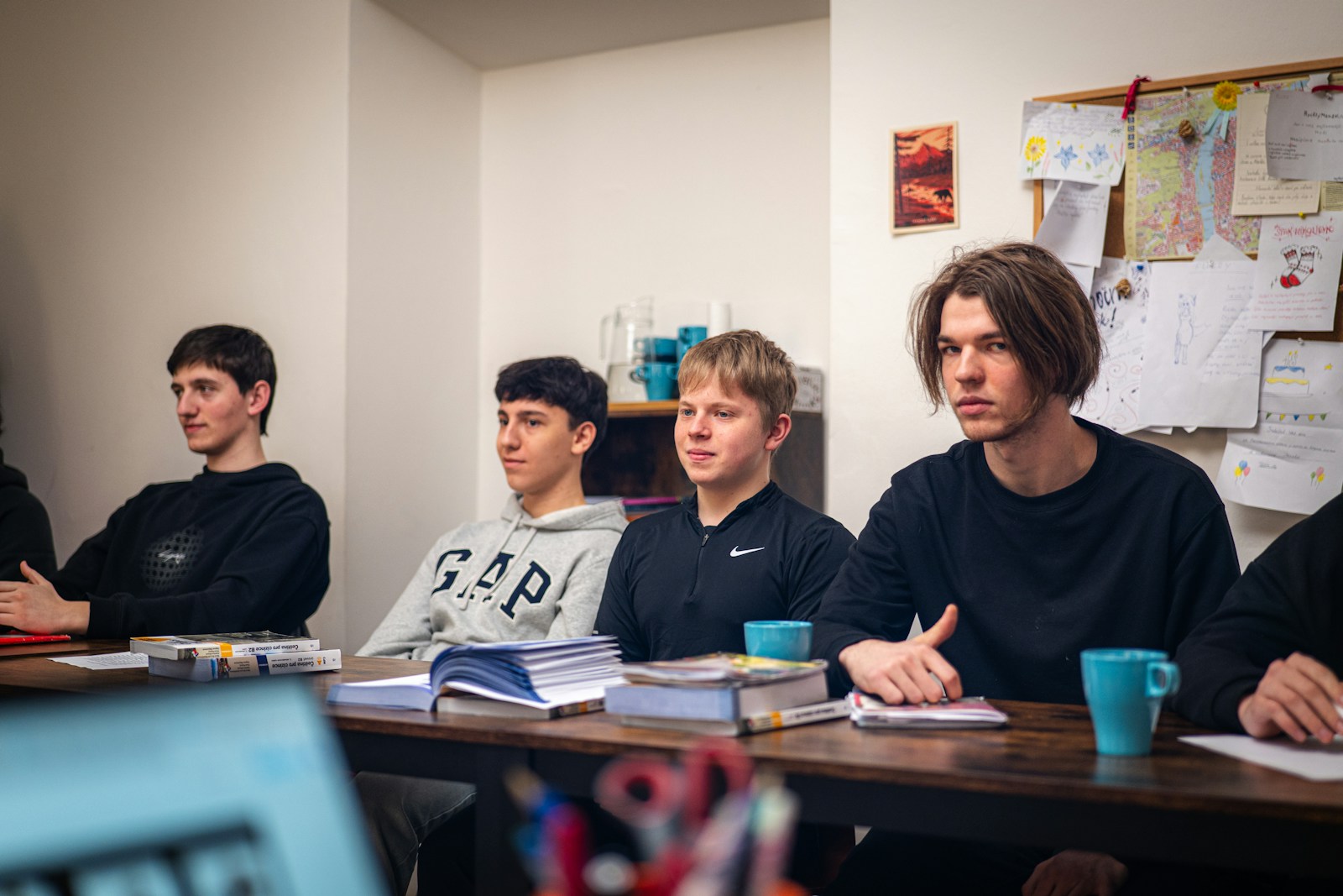 Young men attentively listening in a classroom setting.