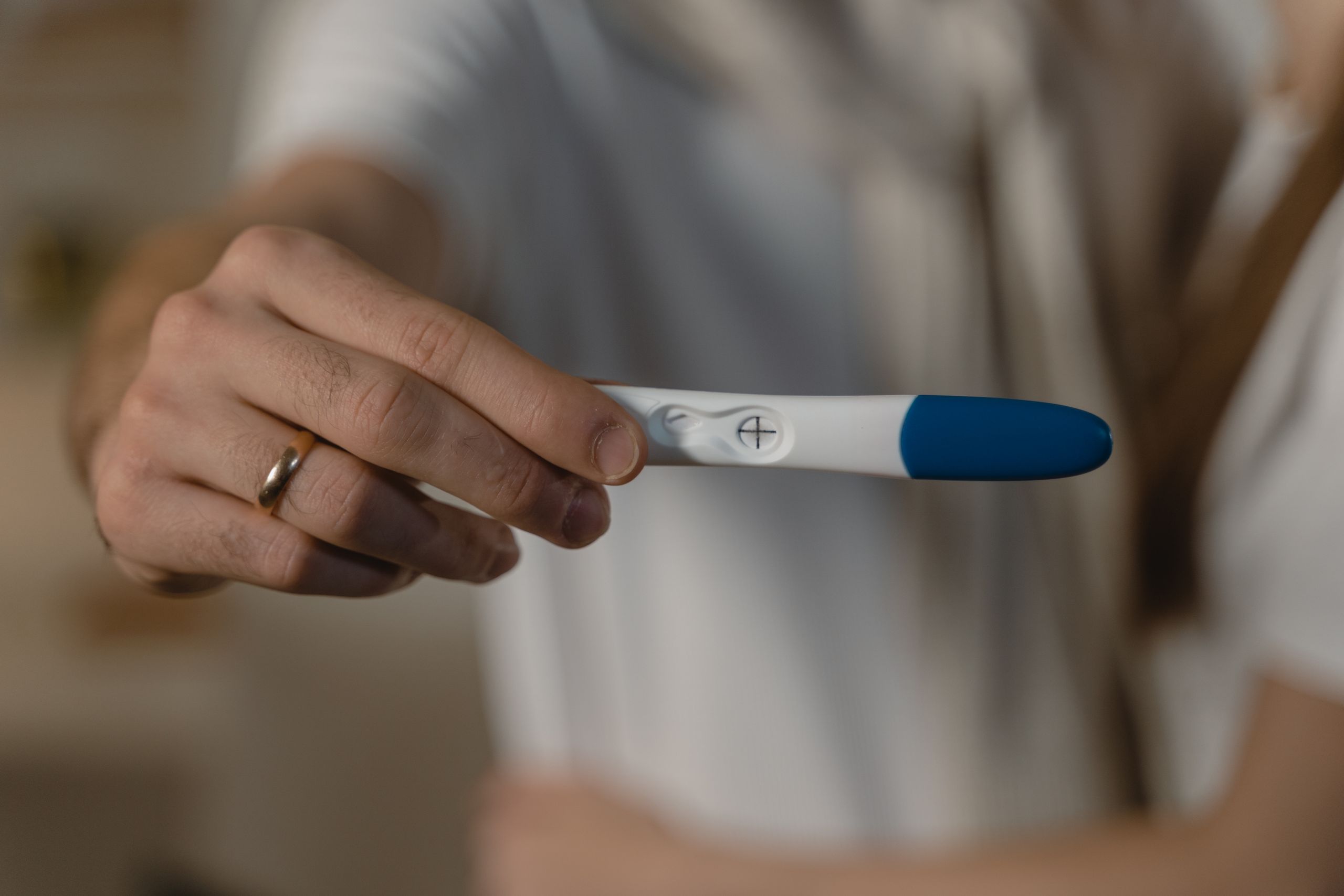 A close-up shot of a positive pregnancy test held by an expecting couple, symbolizing new life.