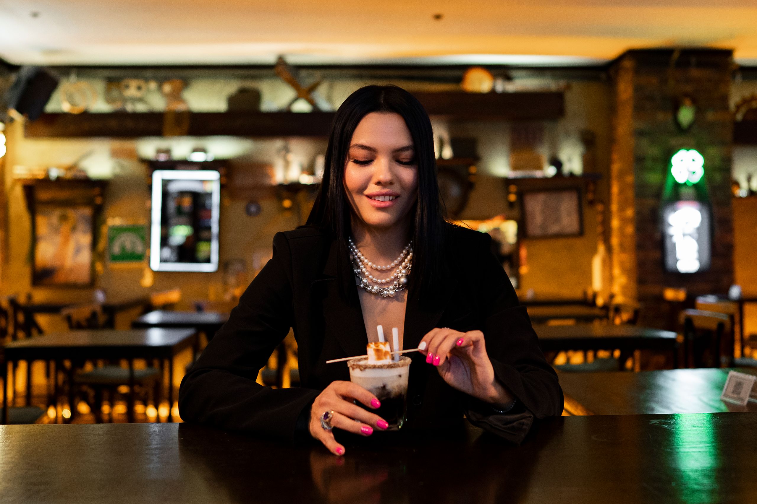 A stylish woman enjoys a cocktail in a cozy İstanbul bar, creating a warm evening vibe.
