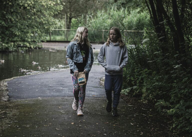 Two people walking down a path in the woods