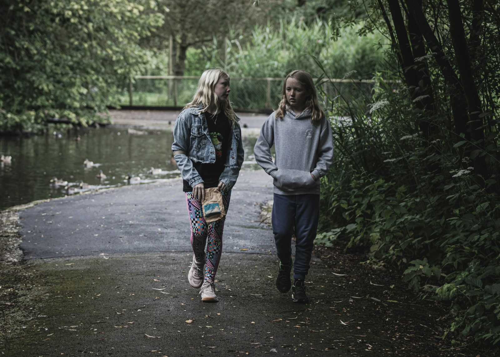 Two people walking down a path in the woods