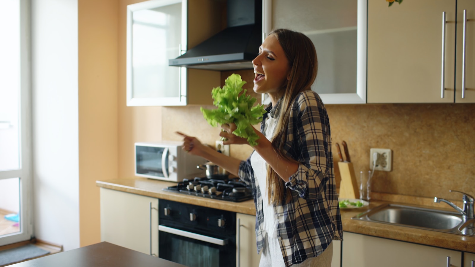 Woman singing and dancing in kitchen with parsley