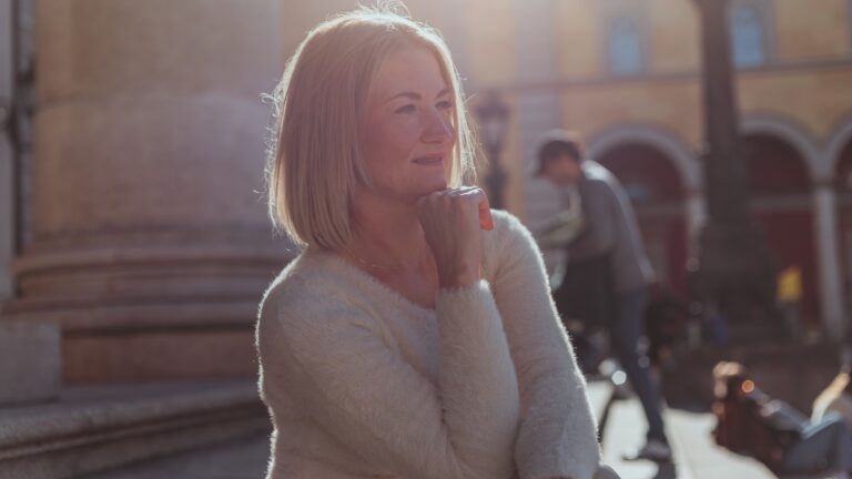A woman standing on a sidewalk talking on a cell phone