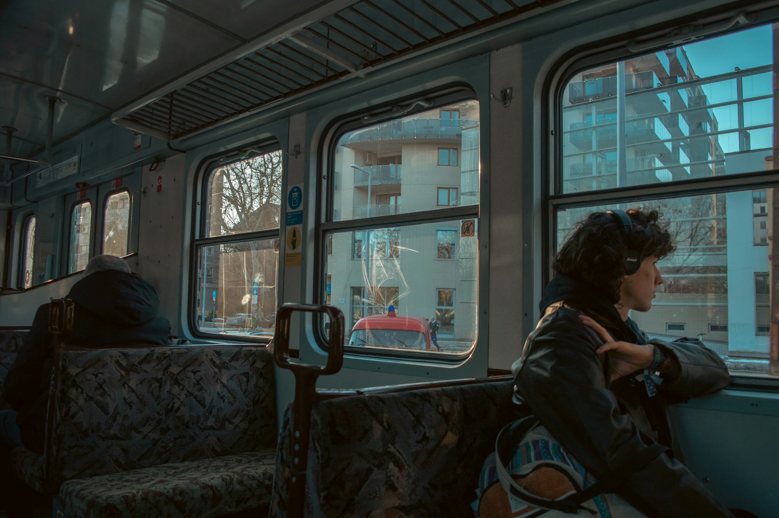 Woman looking out train window at buildings