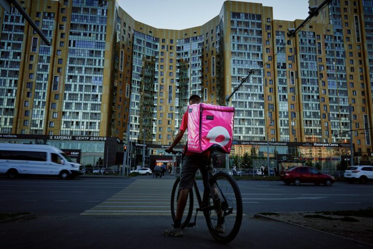 man in red shirt riding bicycle on road during daytime