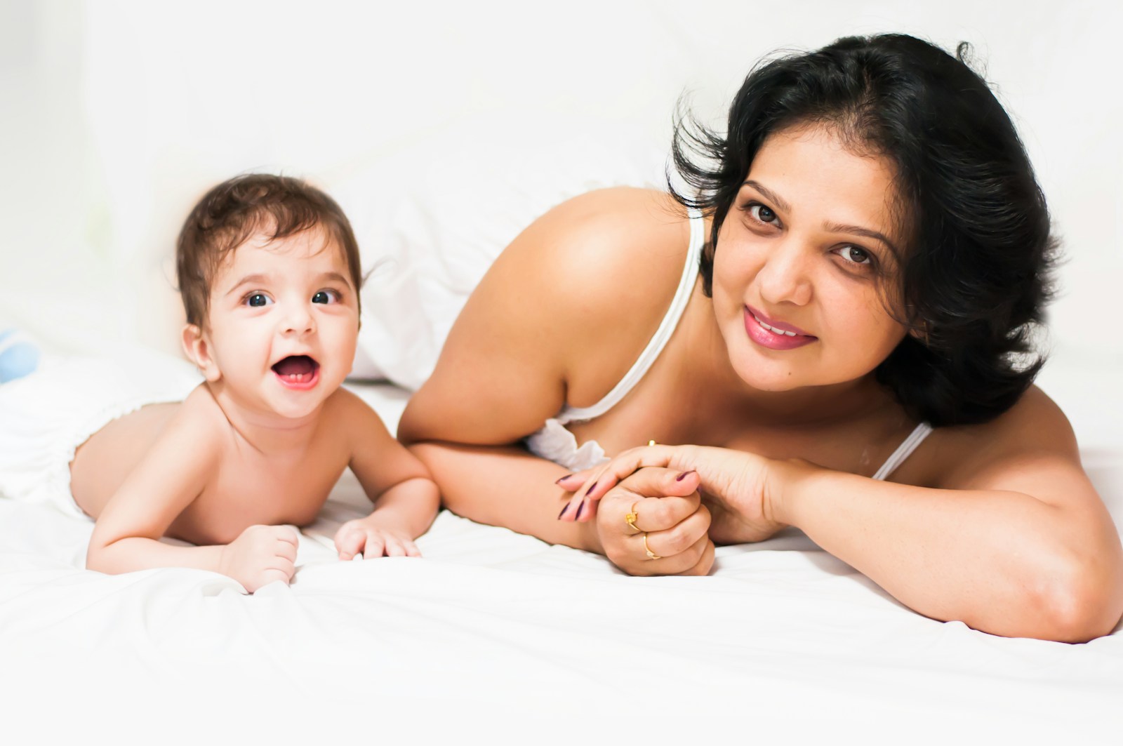 Mother and baby lying on a white surface